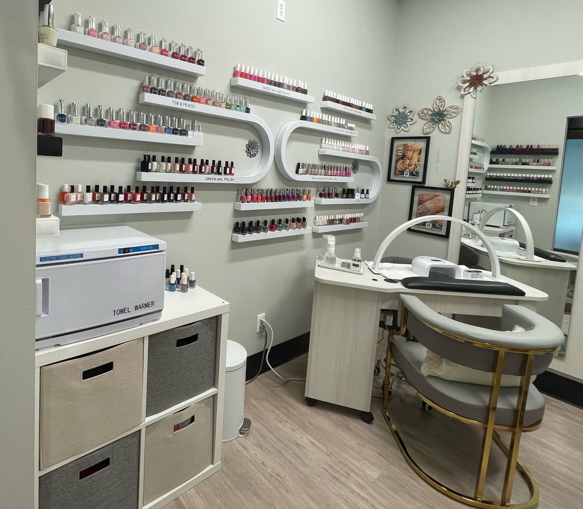 Inside Soraya's Nail Studio — manicure station with extensive nail polish collection, towel warmer, and gold accent client chair